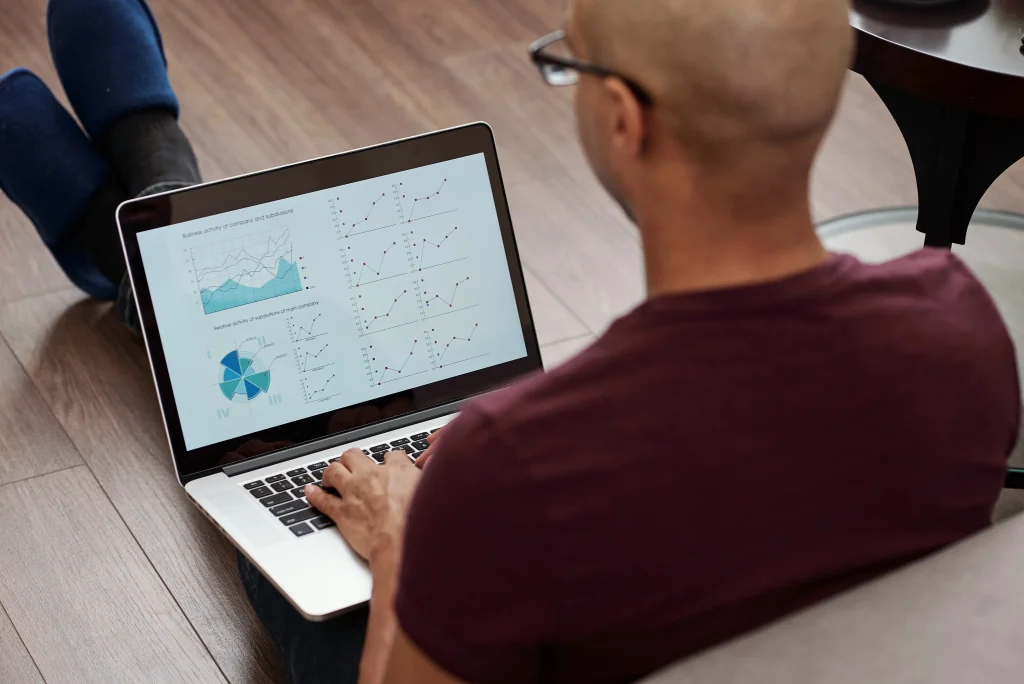 Man sitting on floor working on his laptop looking at nonprofit data