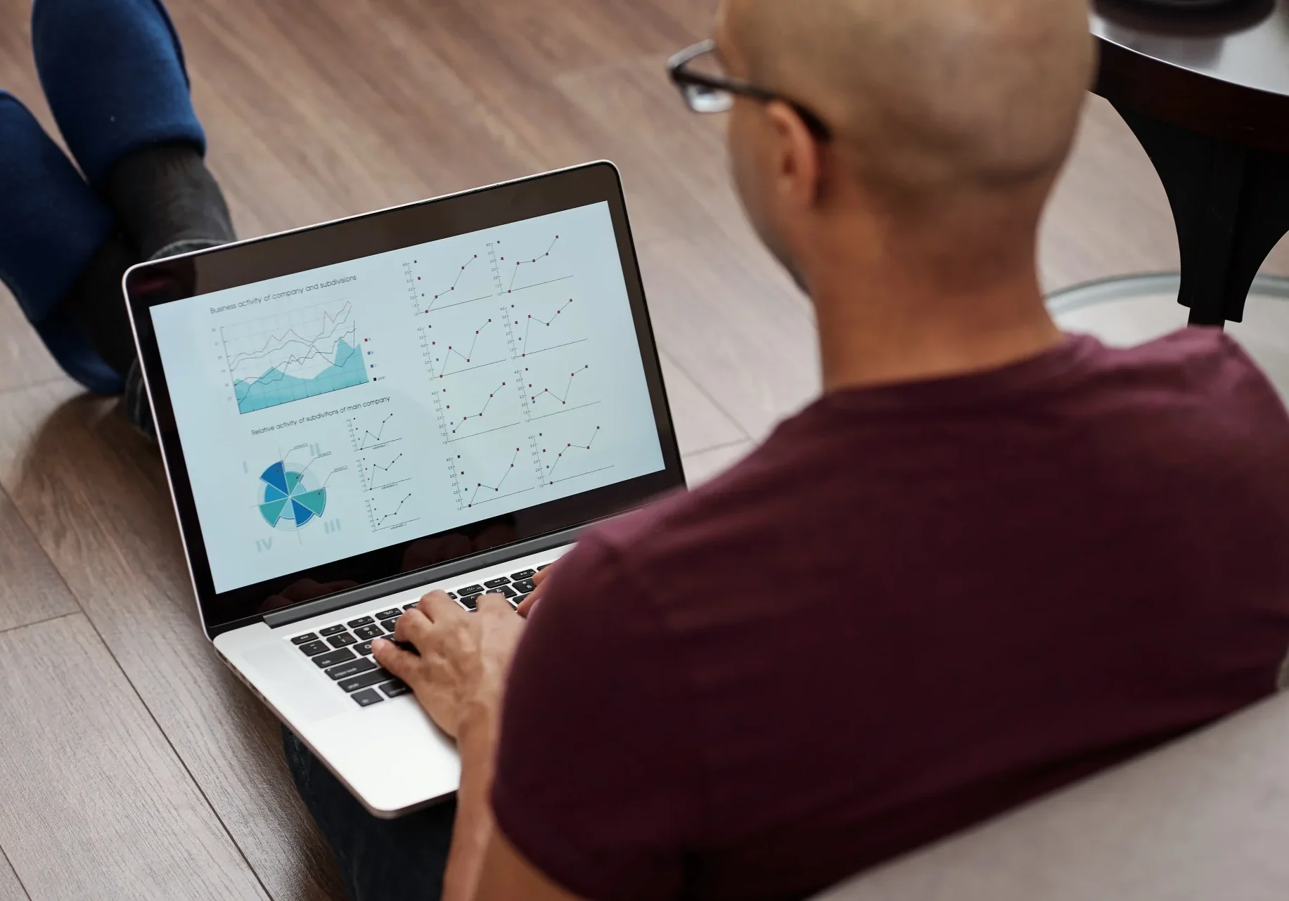 Man sitting on floor working on his laptop looking at nonprofit data